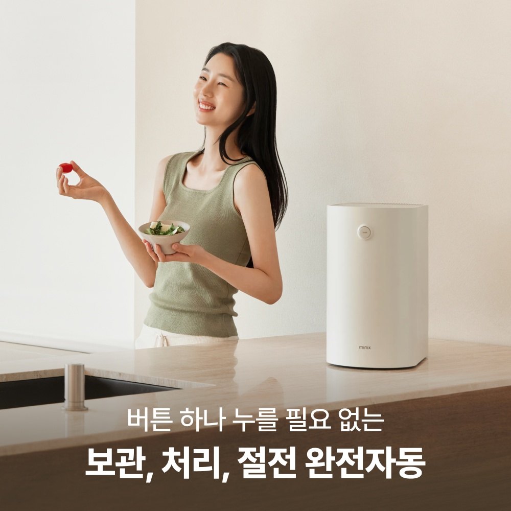 Woman holding a bowl of fruit next to the Minix Plender PRO on a kitchen counter