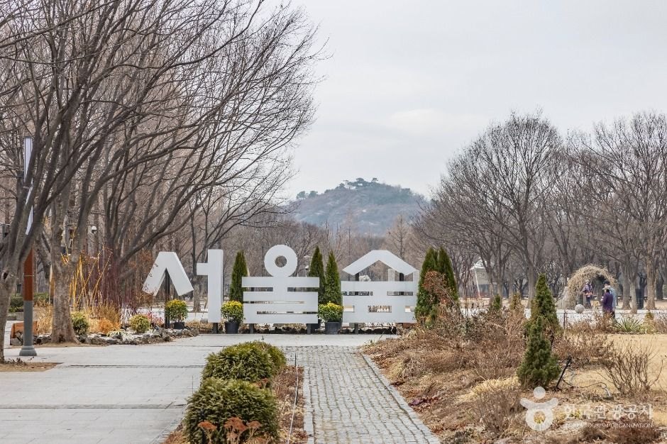 Seoul Forest Korean sign at the park entrance with bare trees and paths