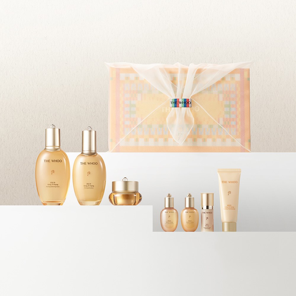 The Whoo Gongjinhyang Royal 3-Piece Set gold bottles, cream jar and foam in front of a dancheong bojagi gift box